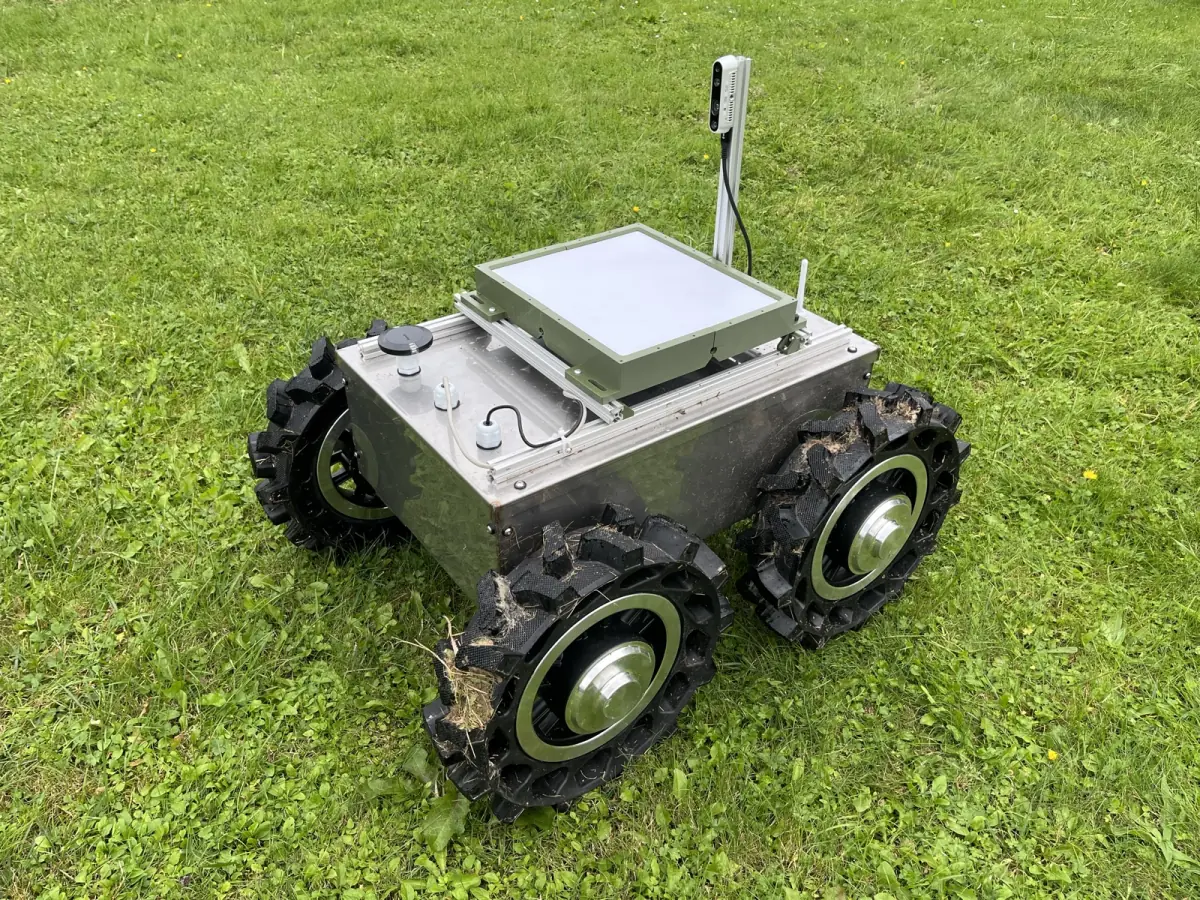 UGV1, a four-wheeled metal ground robot, on a field of grass