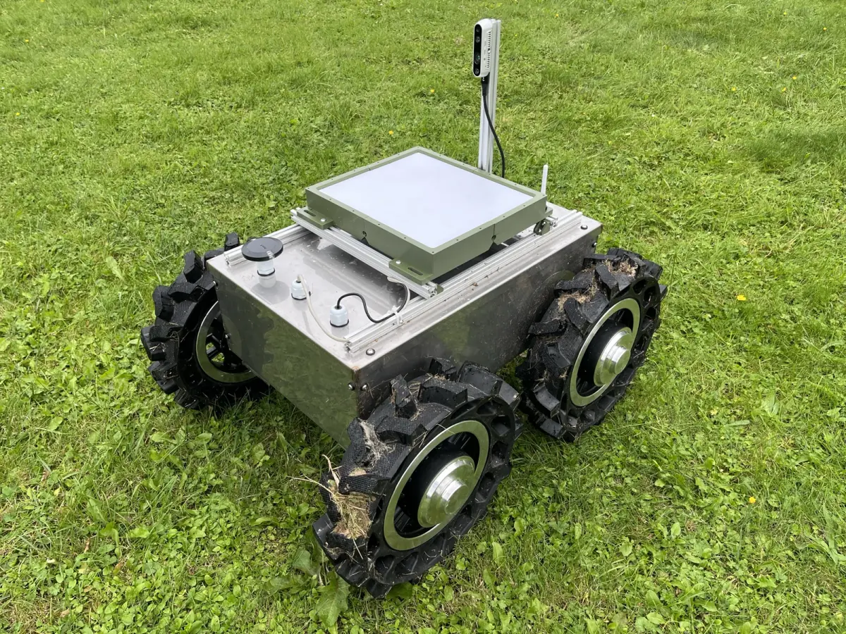 UGV1, a four-wheeled metal ground robot, parked on grass